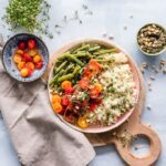 Färgstark lunchskål med lax, quinoa, gröna bönor och tomater